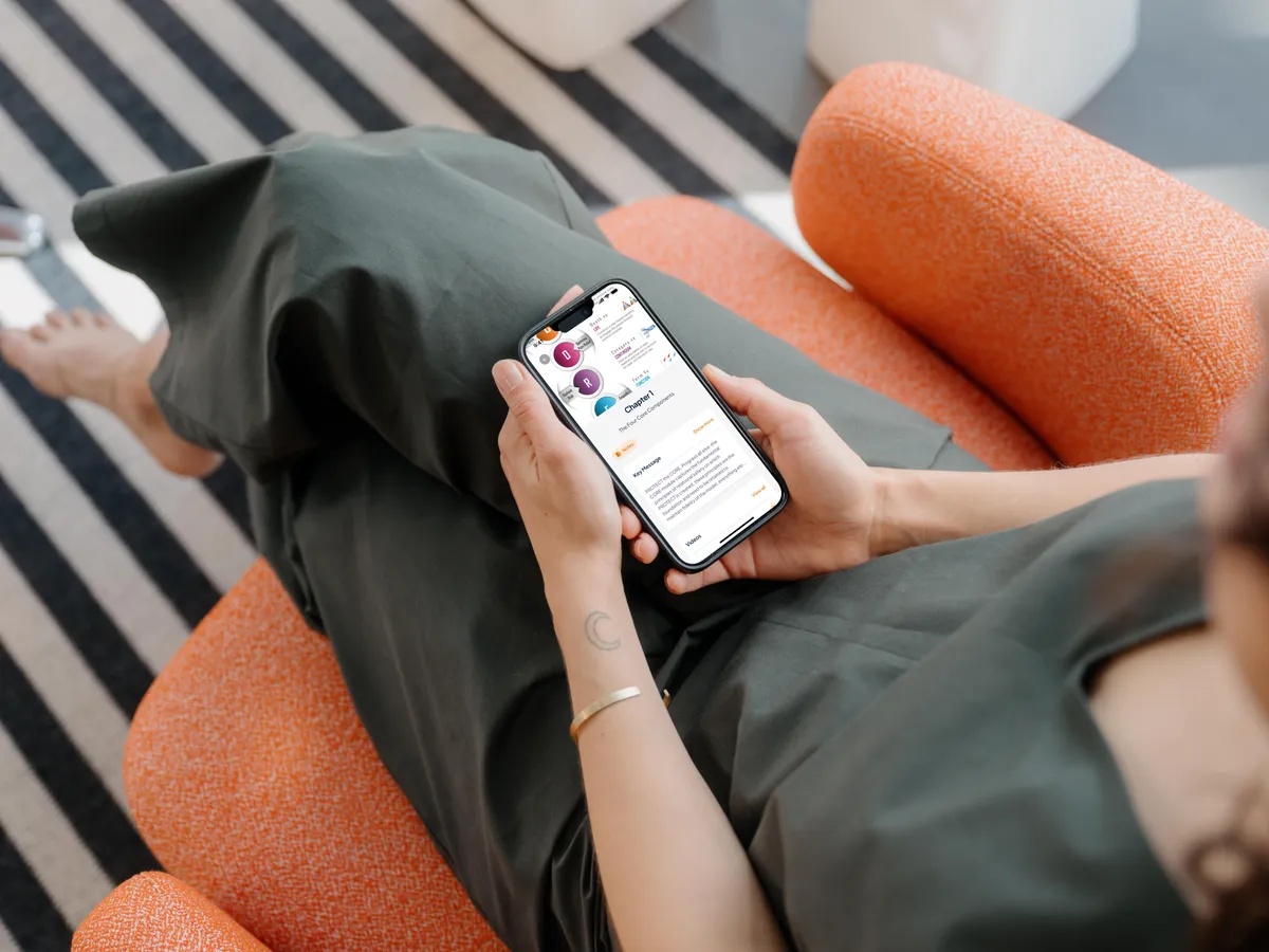 Person relaxing on a chair while checking the Safe Guide Life app on their phone