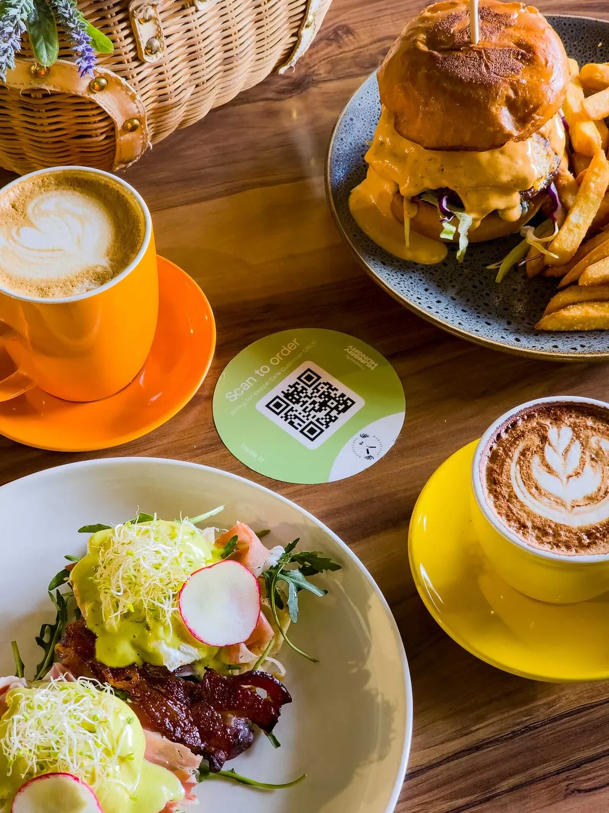 Table spread of a burger, fries, and coffees with a HungryHungry QR scan-to-order table tent